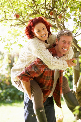 Couple picking apples off tree