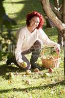 Woman collecting apples off the ground