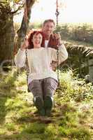Couple with country garden swing
