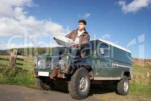 Young man in countryside with SUV