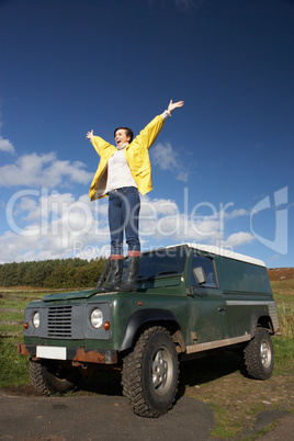 Young woman in countryside with SUV