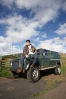 Young man in countryside with SUV