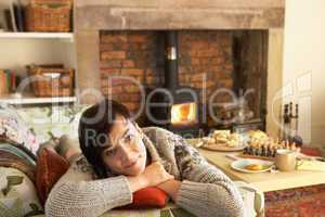 Young woman relaxing by fire