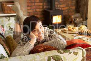 Young woman relaxing by fire
