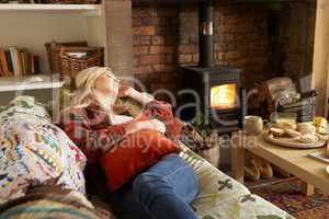 Young woman relaxing by fire