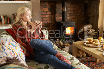 Young woman relaxing by fire