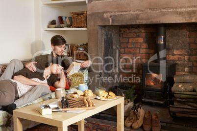 Young couple relaxing by fire