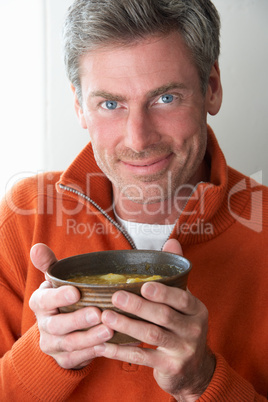 Man holding bowl of soup