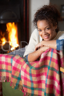Young woman sitting by open fire