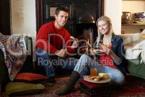 Young couple making toast on open fire