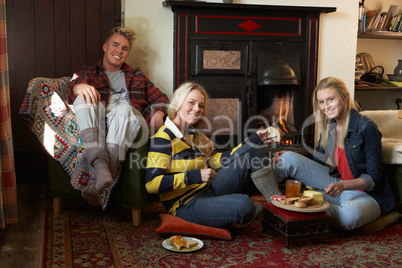 Young adults making toast on open fire
