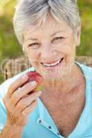 Senior woman eating apple