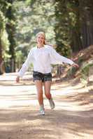 Woman running along country lane