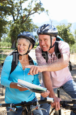 Senior couple with map on country bike ride