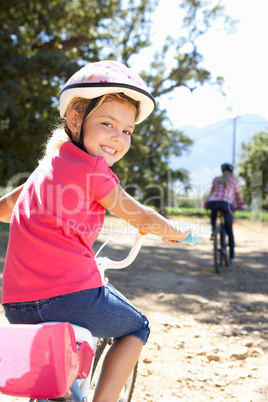 Little girl on country bike ride with mom