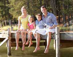 Young family sitting by lake