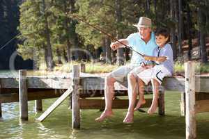 Senior man fishing with grandson