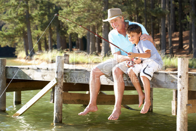 Senior man fishing with grandson