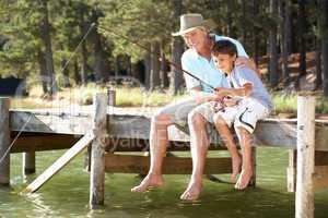 Senior man fishing with grandson