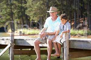 Senior man fishing with grandson