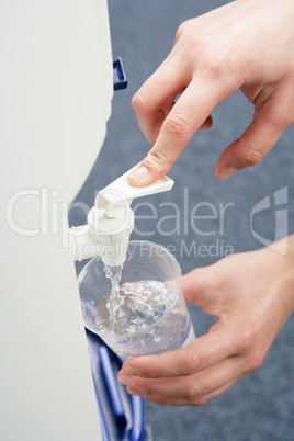 Woman filling cup at water cooler