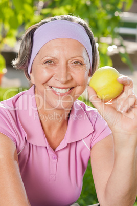 Senior sportive woman smile eat apple outdoor