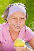 Senior sportive woman smile eat apple outdoor