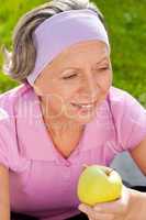 Senior sportive woman smile eat apple outdoor