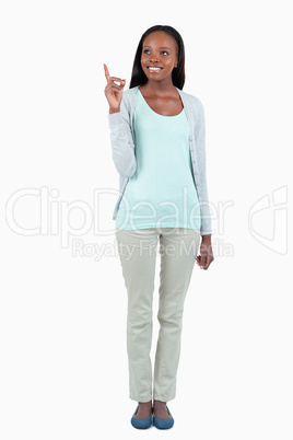 Smiling young woman pointing upwards Smiling young woman pointing upwards
