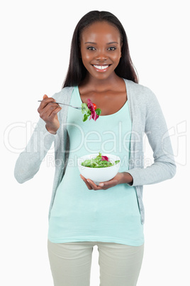 Young woman eating salad