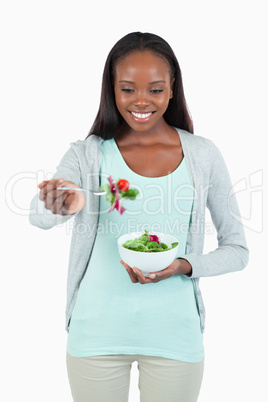 Young woman with salad on her fork