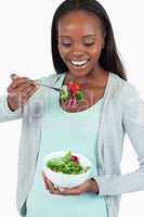 Happy young woman eating salad