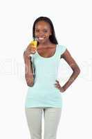 Smiling young woman having a sip of orange juice