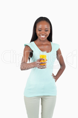 Glass of orange juice being held by smiling young woman