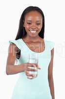 Happy smiling woman looking at the glass of water in her hand