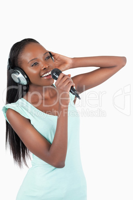 Young woman with headphones singing