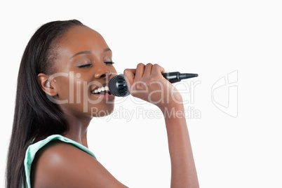 Smiling young woman singing into a microphone