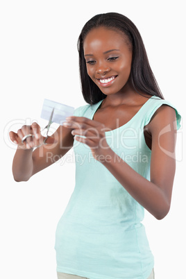 Smiling young woman destroying her credit card