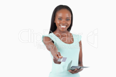 Smiling young woman using her credit card to pay