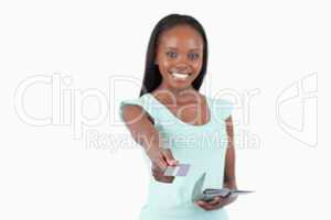 Smiling young woman using her credit card to pay