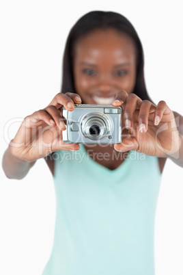 Camera used for taking photos by smiling young woman
