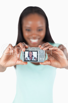 Smiling young woman taking picture of herself