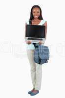 Smiling young student showing her laptop