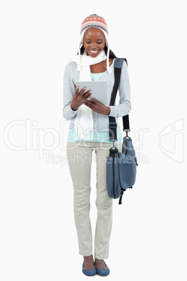 Smiling young student with hat, scarf and touchpad