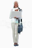 Smiling female student in winter clothing and laptop