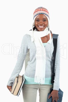 Smiling student with books in winter clothes