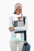 Smiling young student in winter clothes with her books