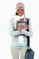 Smiling young woman with winter clothes and books
