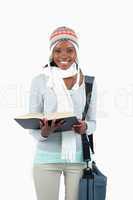Smiling young student in winter clothing and book