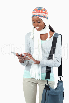 Smiling young woman in winter clothes using her tablet